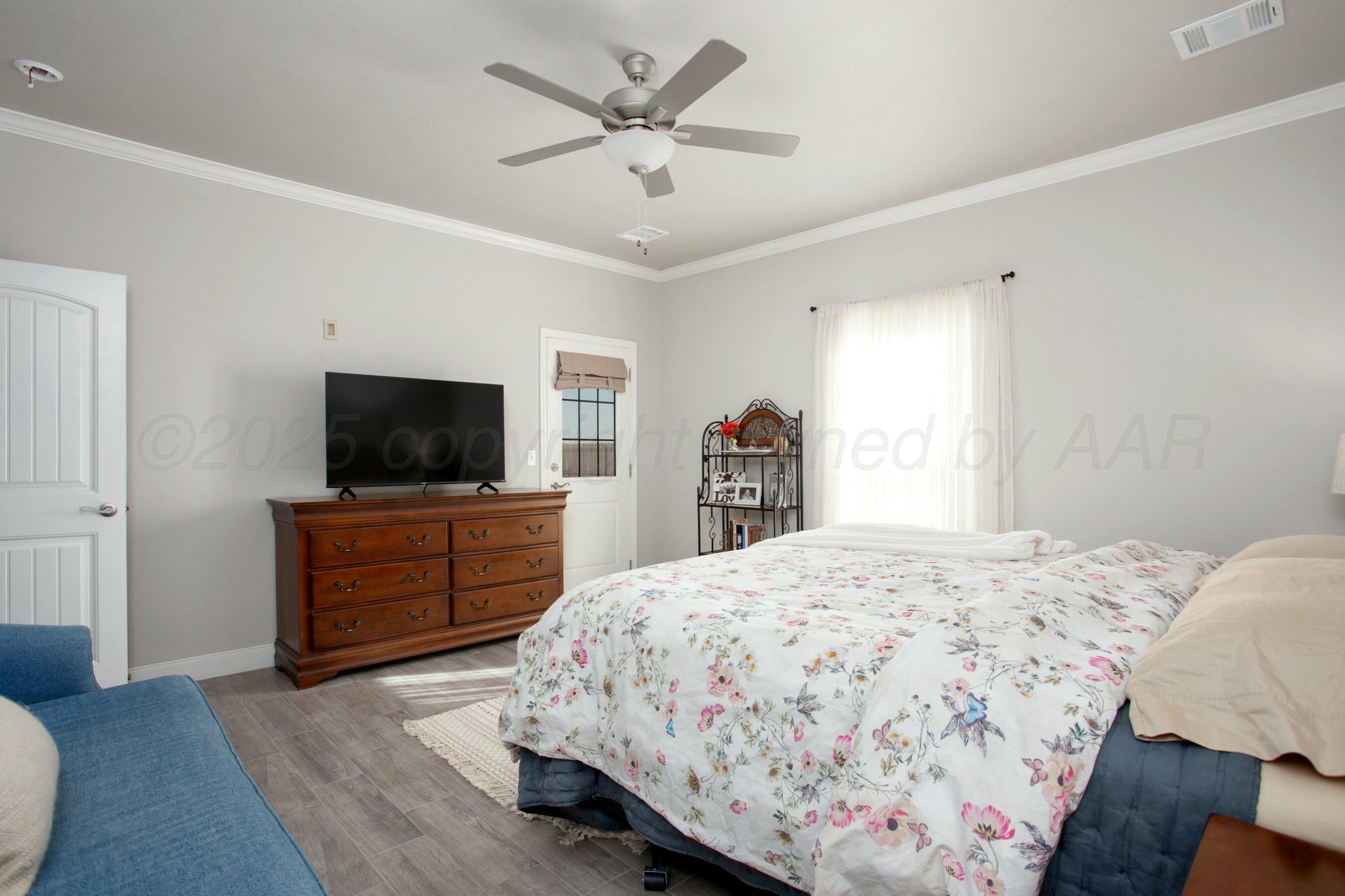 18501 Helium Road Canyon, TX 79015 - Photo 16 of 28 a bedroom with a bed and a flat screen tv