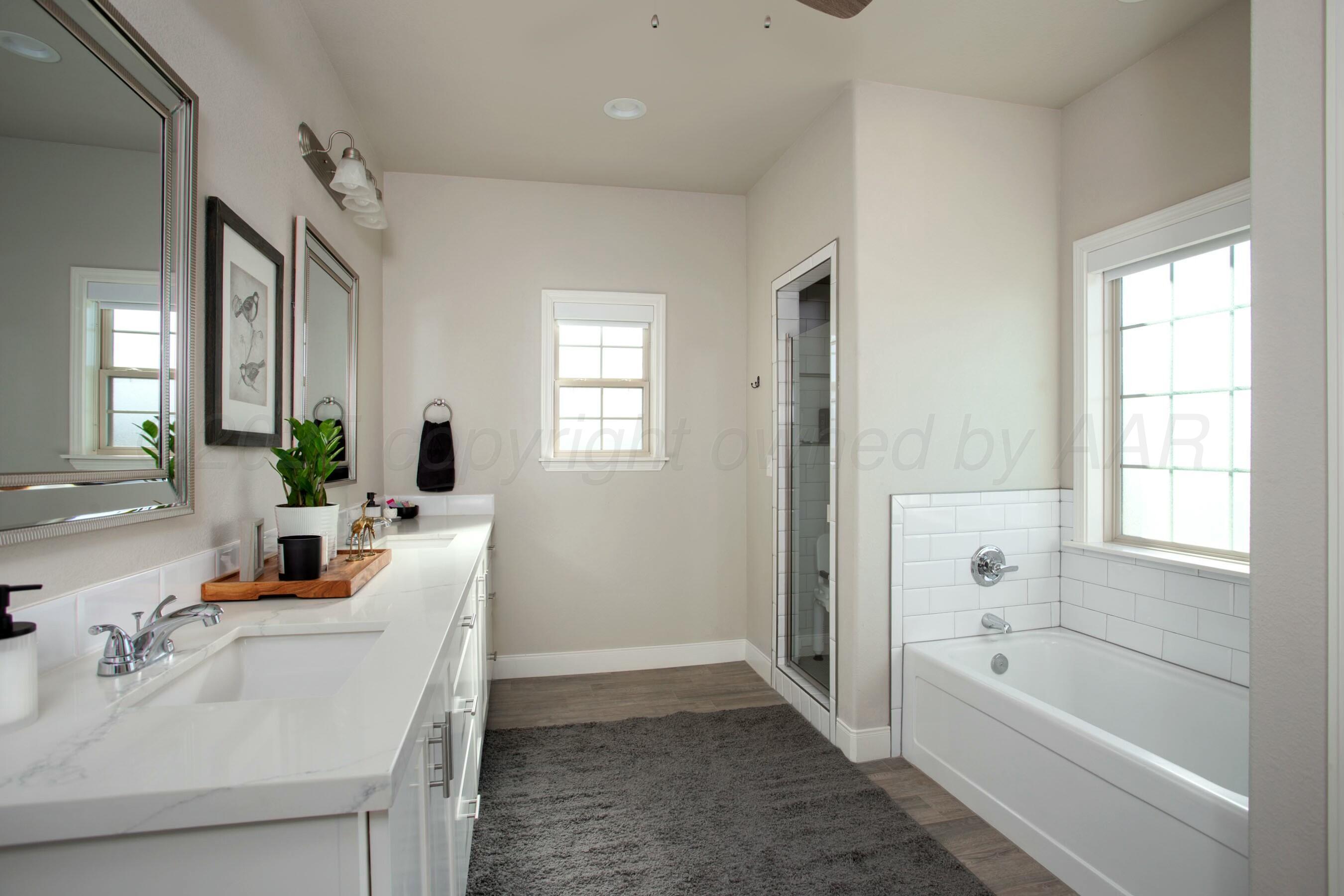18501 Helium Road Canyon, TX 79015 - Photo 17 of 28 a bathroom with a tub sink and mirror