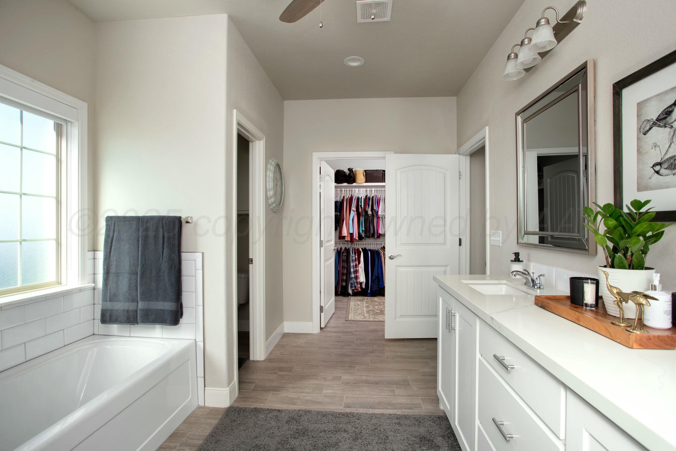 18501 Helium Road Canyon, TX 79015 - Photo 18 of 28 a bathroom with a tub sink and a mirror