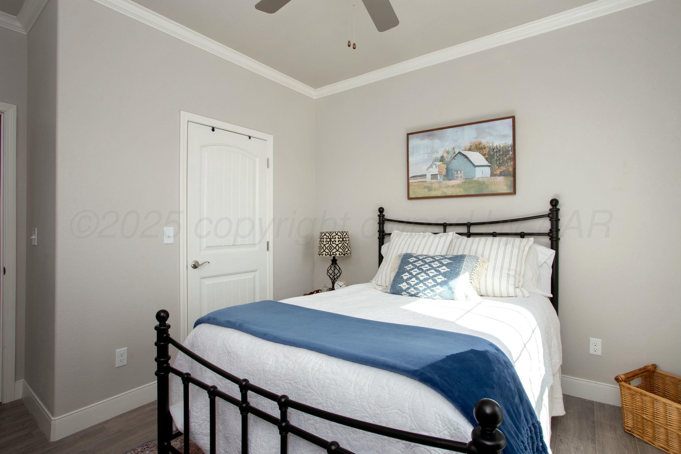 18501 Helium Road Canyon, TX 79015 - Photo 21 of 28 a bedroom with a bed and a painting on the wall