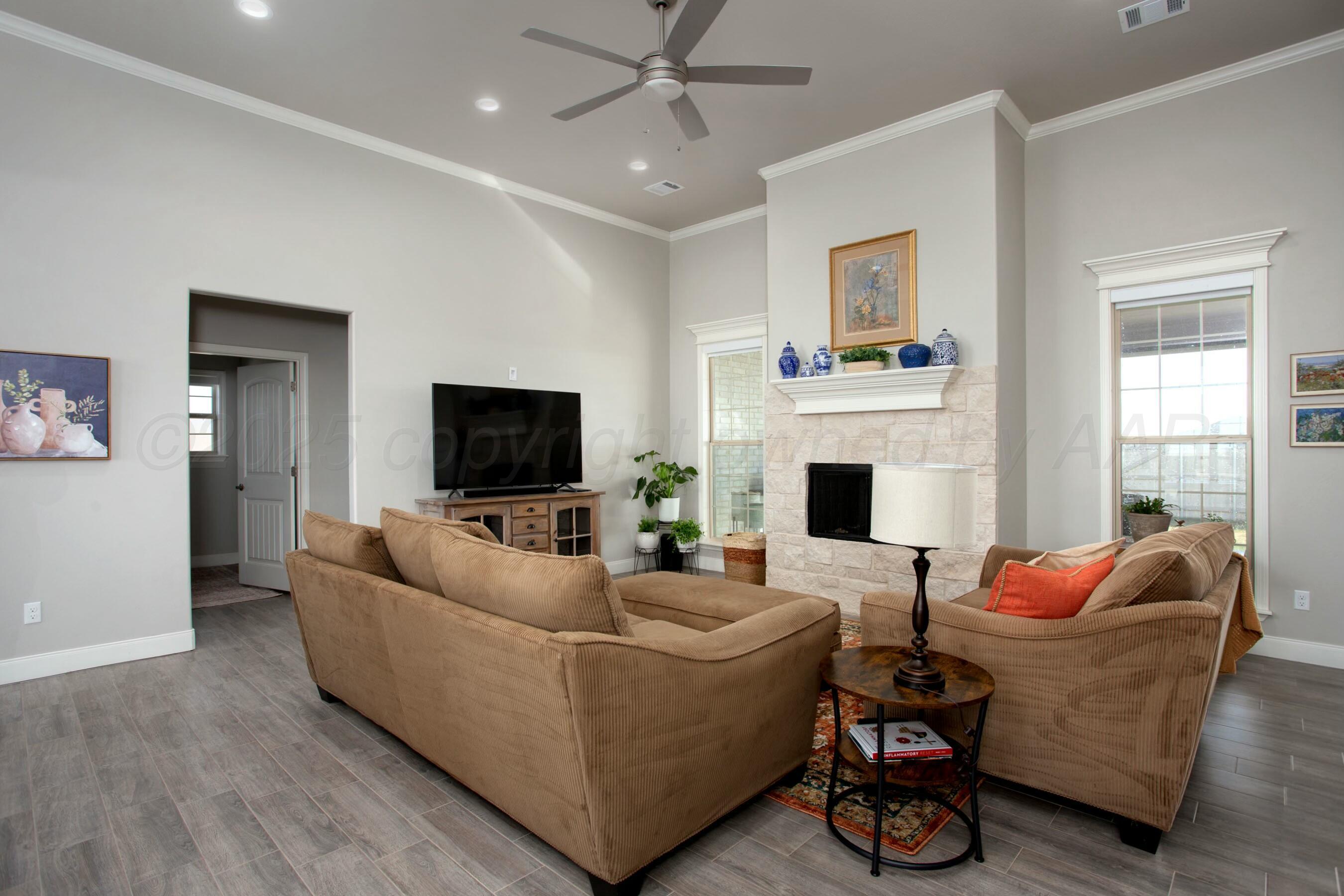 18501 Helium Road Canyon, TX 79015 - Photo 5 of 28 a living room with furniture a flat screen tv and a fireplace
