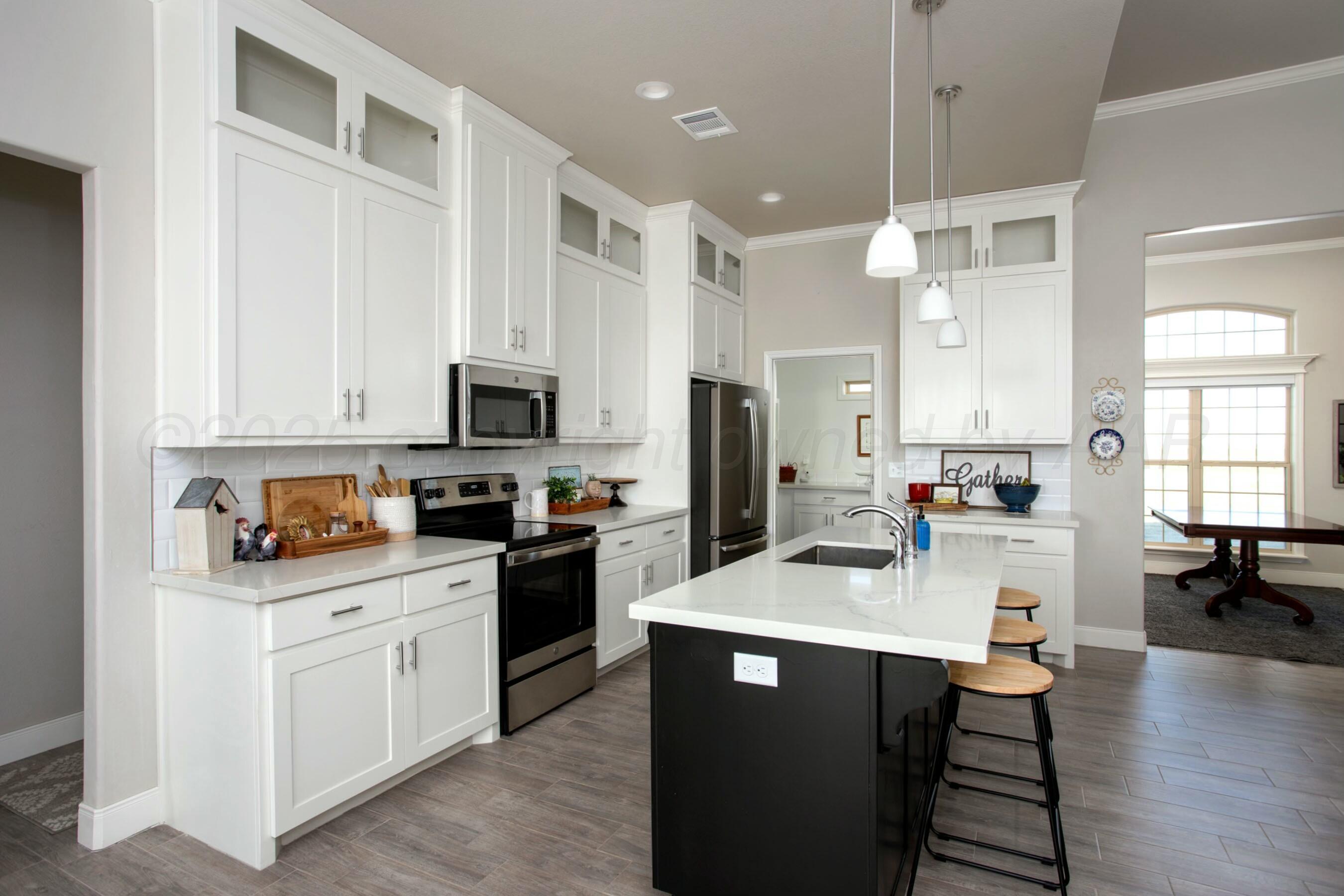18501 Helium Road Canyon, TX 79015 - Photo 9 of 28 a kitchen with white cabinets and appliances