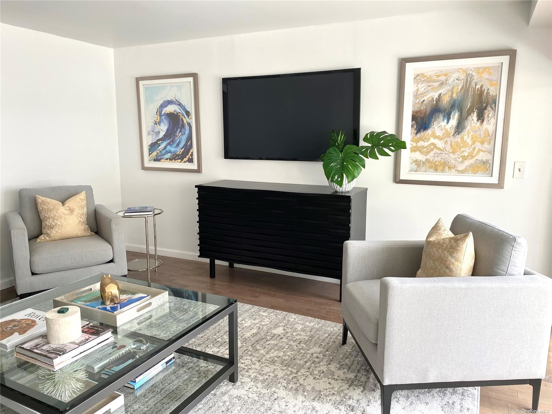 88 Cutter Mill Road, Unit 420 Great Neck, NY 11021 - Photo 1 of 1 a living room with furniture a flat screen tv and a fireplace