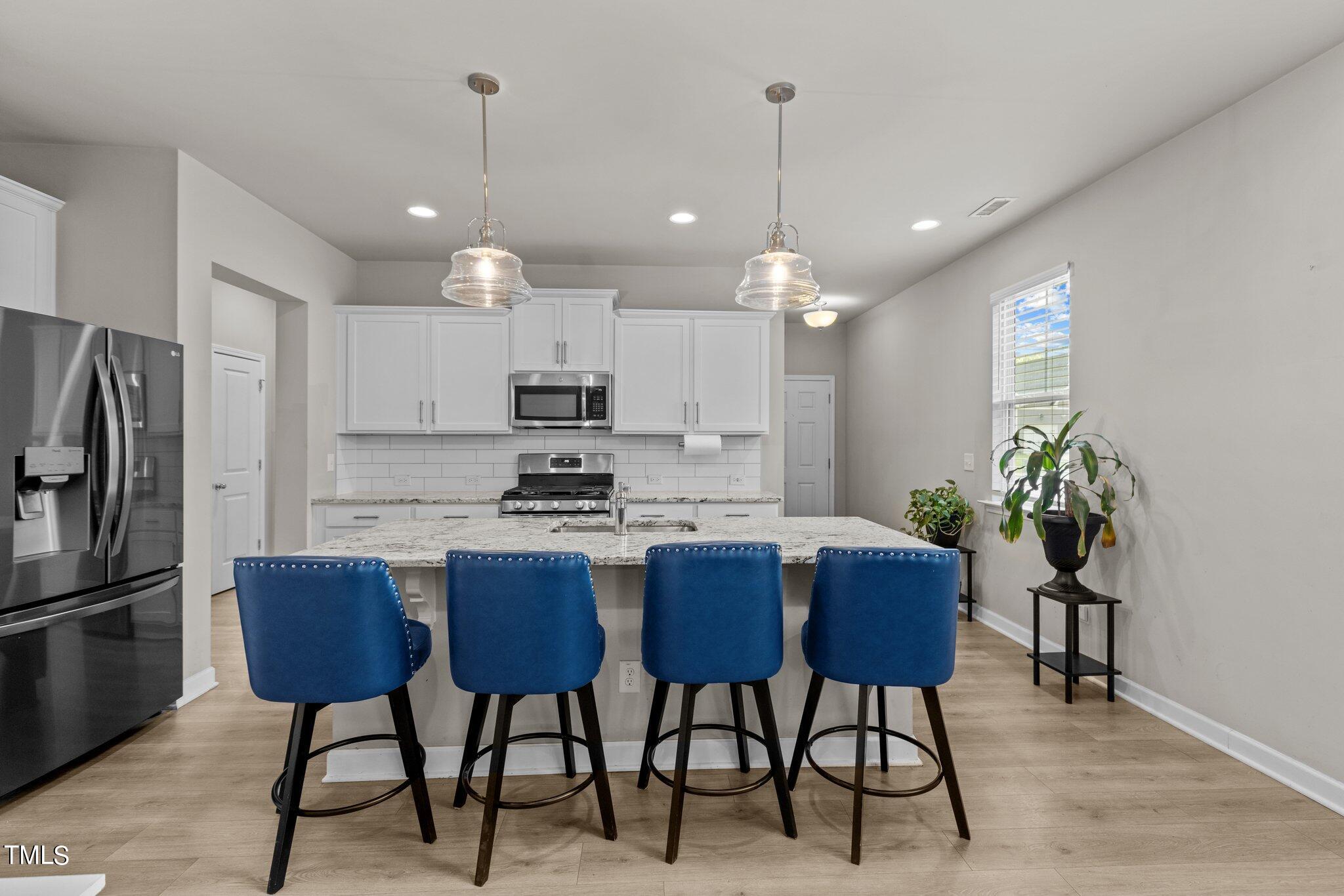 36 Mae Court Roxboro, NC 27573 - Photo 6 of 34 a kitchen with stainless steel appliances kitchen island granite countertop a dining table chairs and a refrigerator