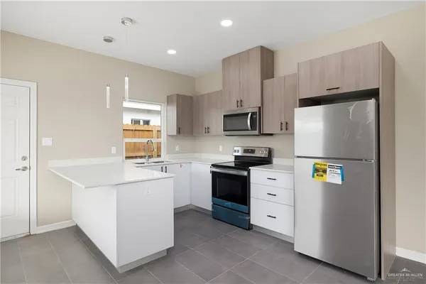 a kitchen with stainless steel appliances a refrigerator sink and white cabinets