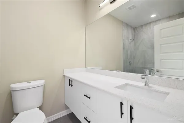 a bathroom with a sink a toilet and a mirror