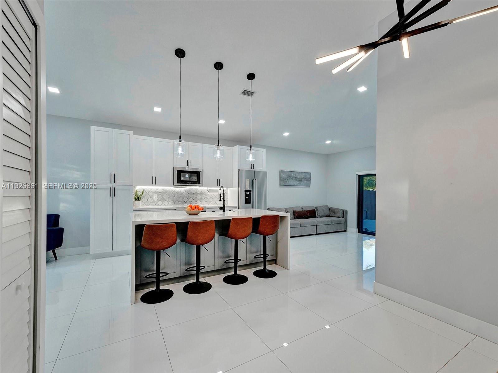 19901 Northwest 77th Court Hialeah, FL 33015 - Photo 16 of 50 a large kitchen with a table and chairs