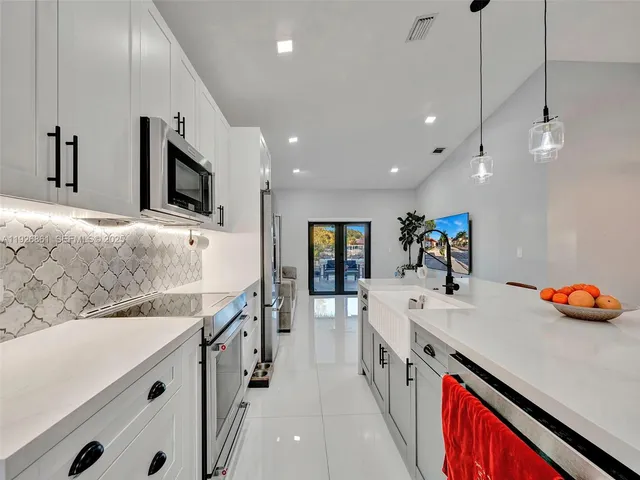 a kitchen with stainless steel appliances a sink and a refrigerator
