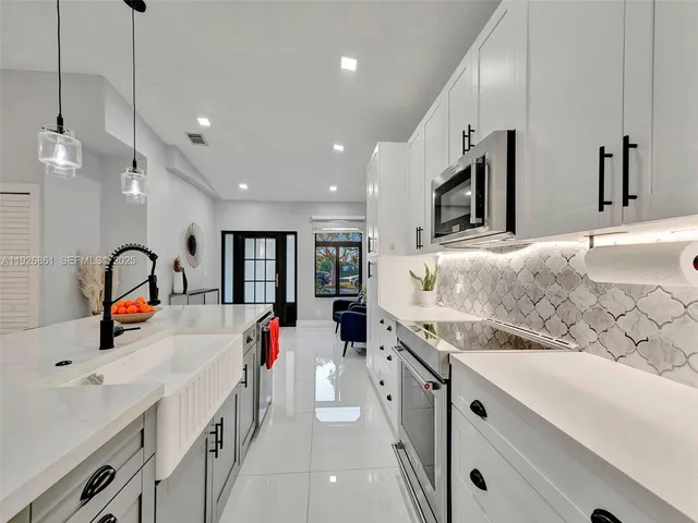 a kitchen with kitchen island granite countertop a stove and a sink