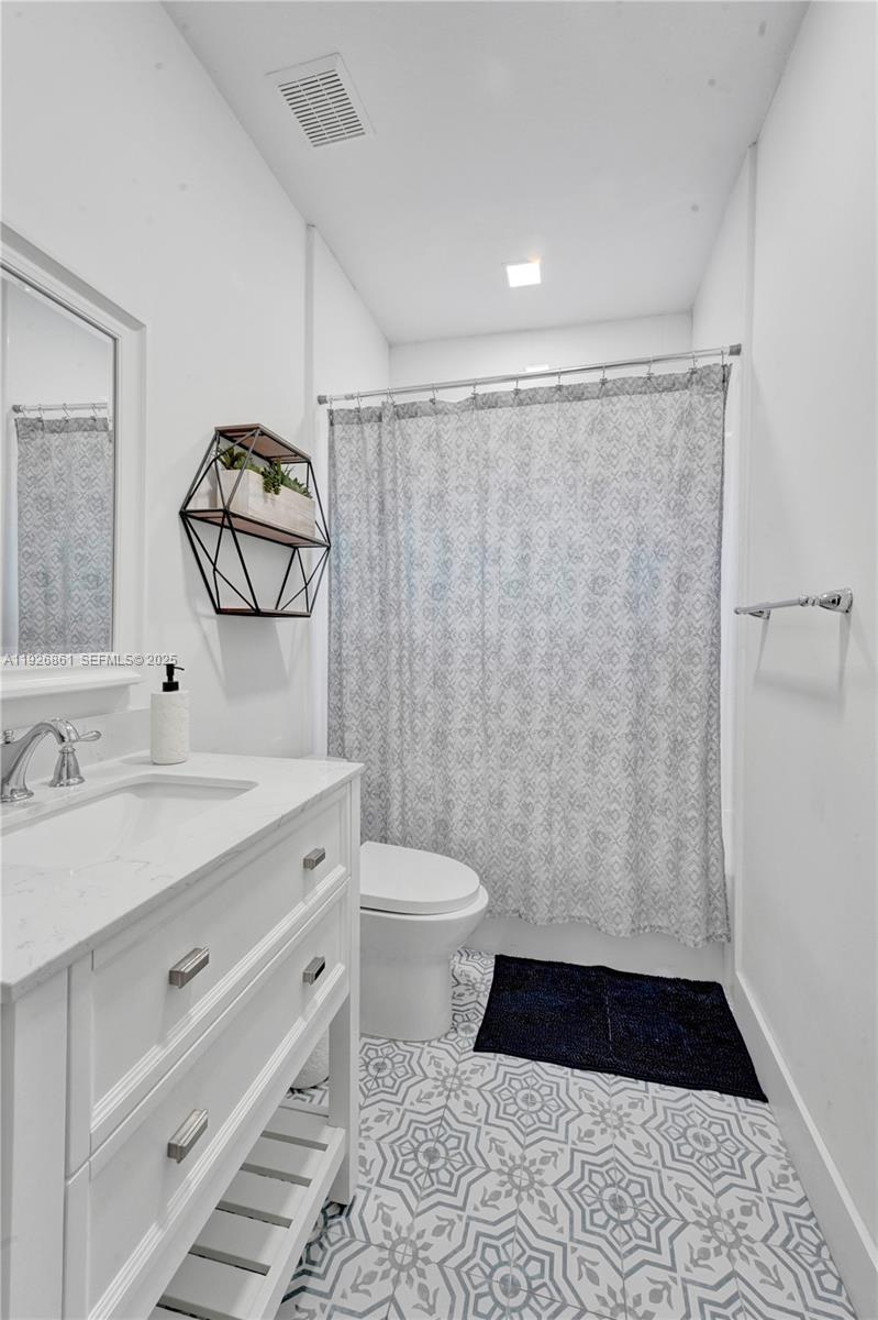 19901 Northwest 77th Court Hialeah, FL 33015 - Photo 25 of 50 a bathroom with a granite countertop sink toilet a mirror and shower