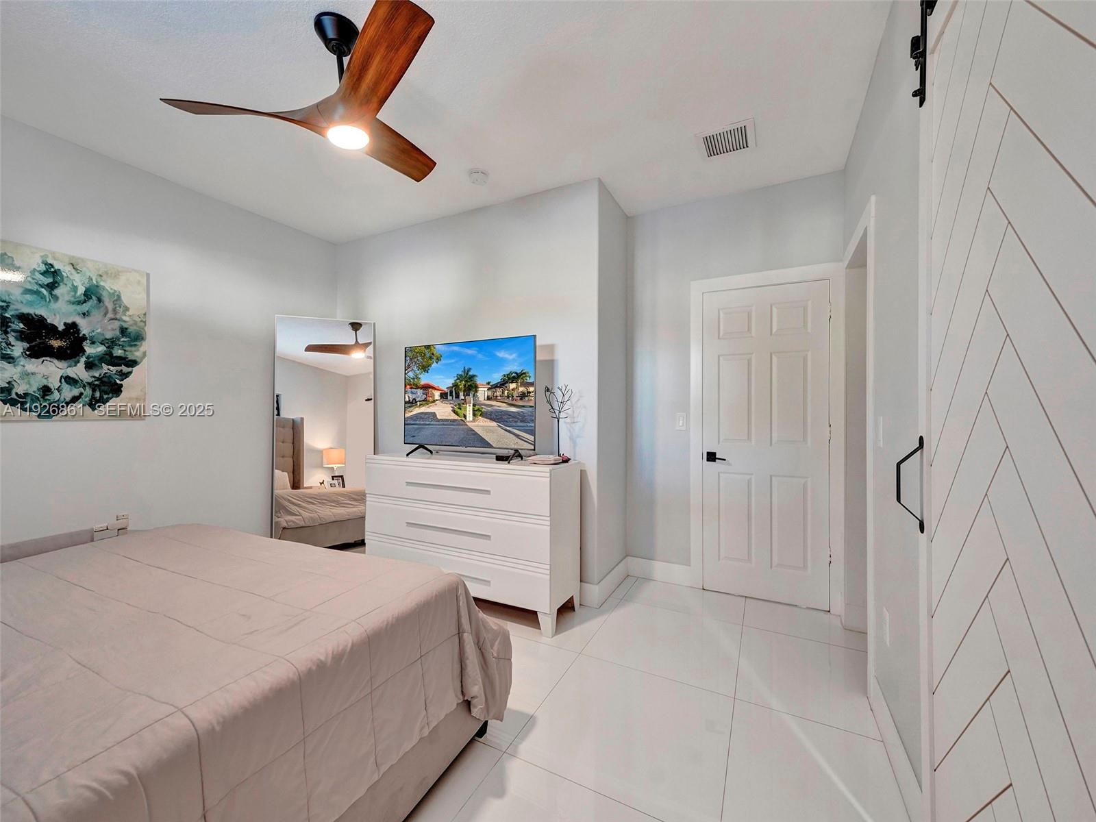 19901 Northwest 77th Court Hialeah, FL 33015 - Photo 28 of 50 a bedroom with a bed and a chandelier