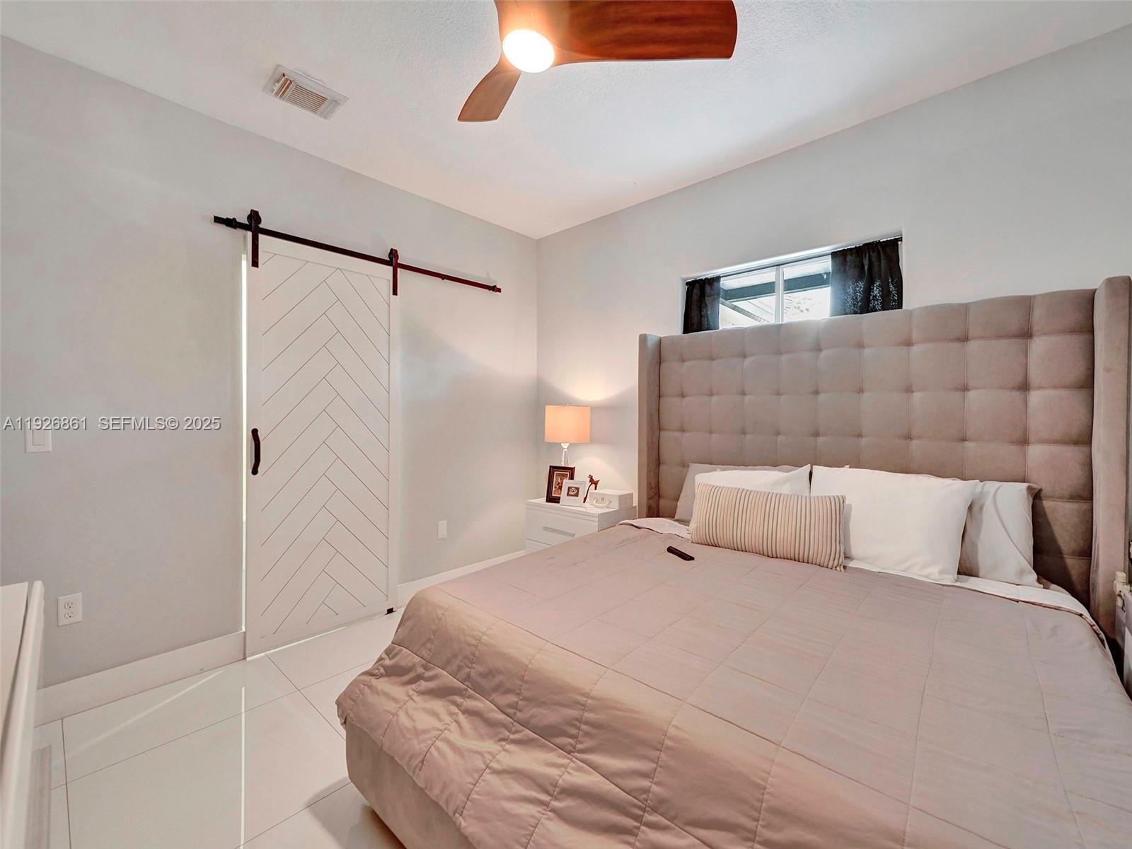 19901 Northwest 77th Court Hialeah, FL 33015 - Photo 30 of 50 a bedroom with a bed and a ceiling fan