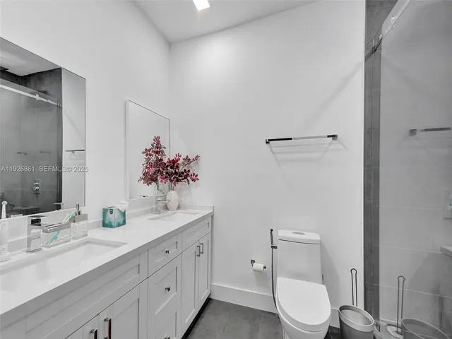 a bathroom with a double vanity sink toilet and mirror