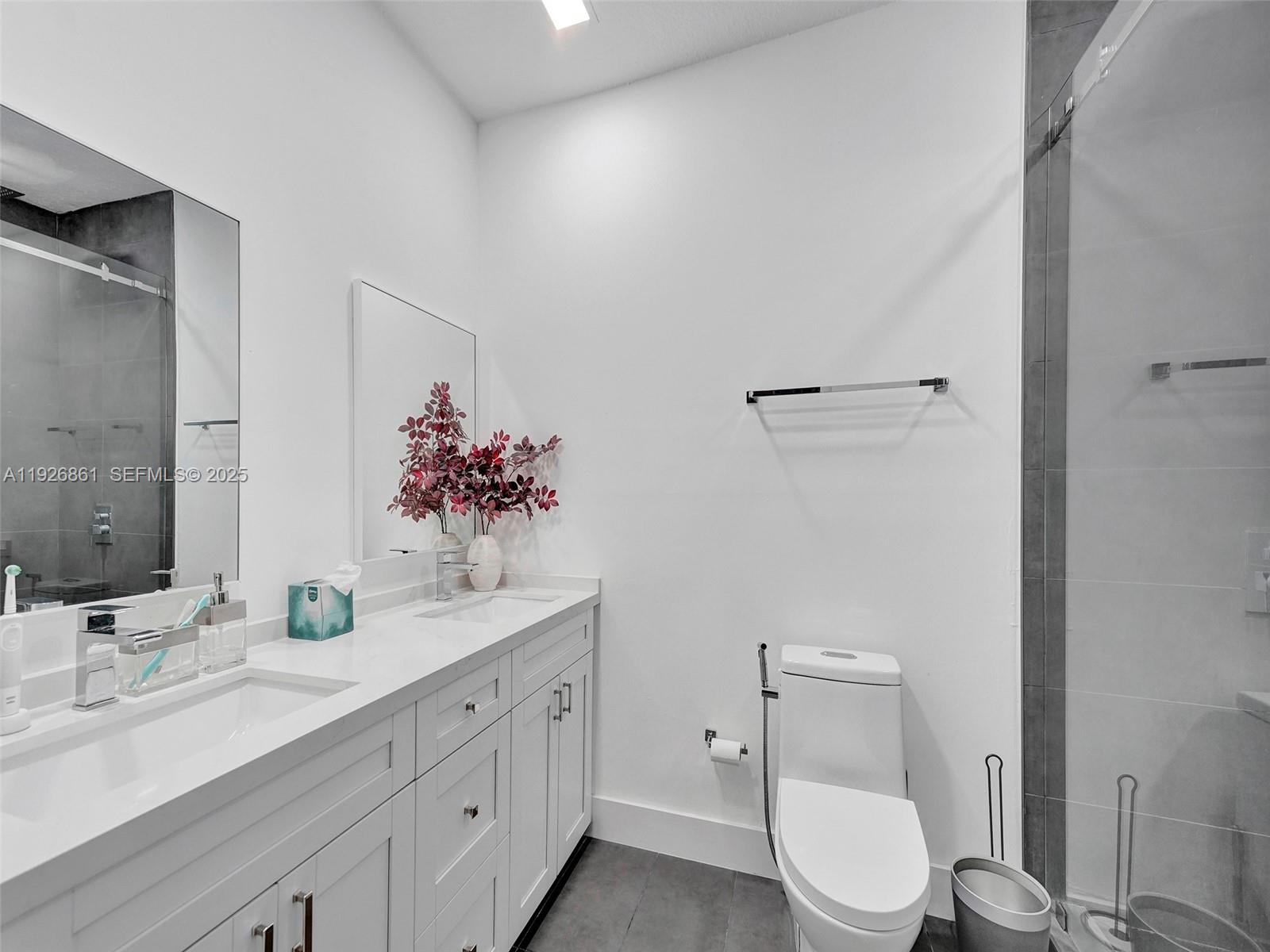 19901 Northwest 77th Court Hialeah, FL 33015 - Photo 32 of 50 a bathroom with a double vanity sink toilet and mirror