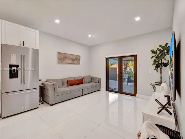 a living room with furniture a window and a flat screen tv