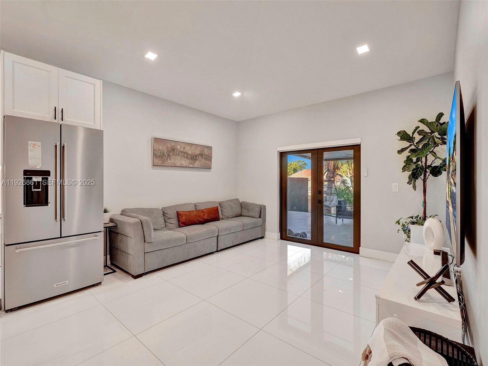 19901 Northwest 77th Court Hialeah, FL 33015 - Photo 9 of 50 a living room with furniture a window and a flat screen tv