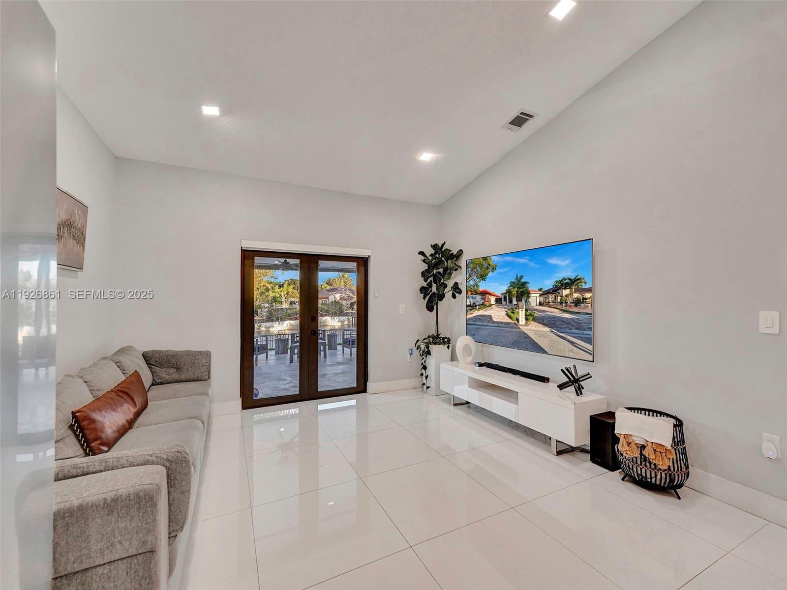 19901 Northwest 77th Court Hialeah, FL 33015 - Photo 10 of 50 a living room with furniture and a flat screen tv