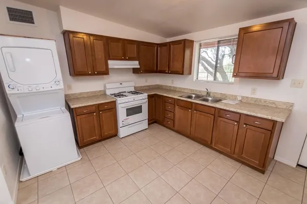 a kitchen with stainless steel appliances granite countertop a sink stove refrigerator and microwave