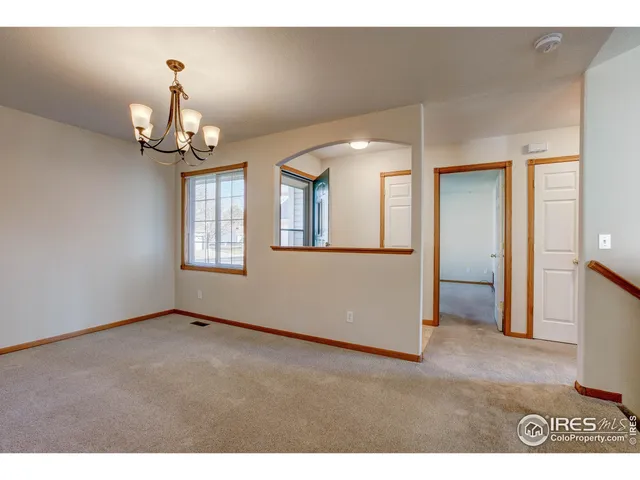 a view of an empty room with window and fire place