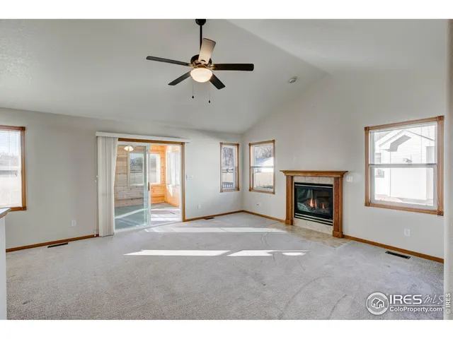 a view of an empty room with a window and fireplace