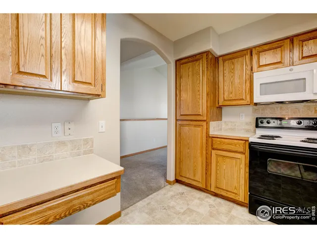 a kitchen with granite countertop wooden cabinets and stainless steel appliances
