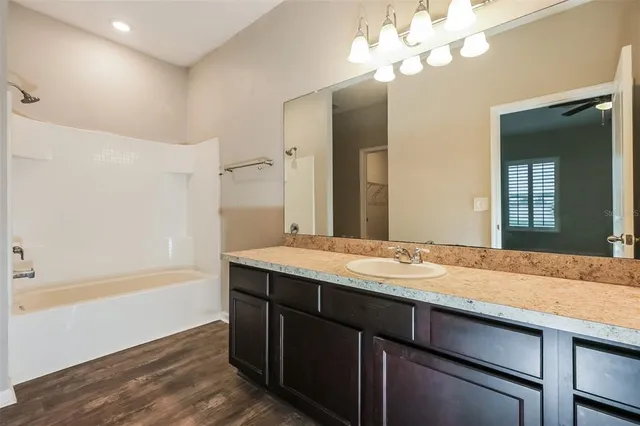 a bathroom with a granite countertop sink a light fixture and a mirror