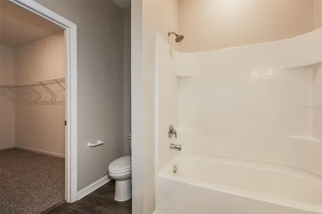 a bathroom with a granite countertop bathtub shower and toilet