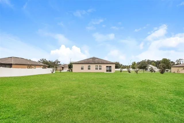 a view of a big yard with a house in the background