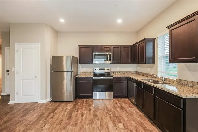 a kitchen with a sink a refrigerator and a microwave