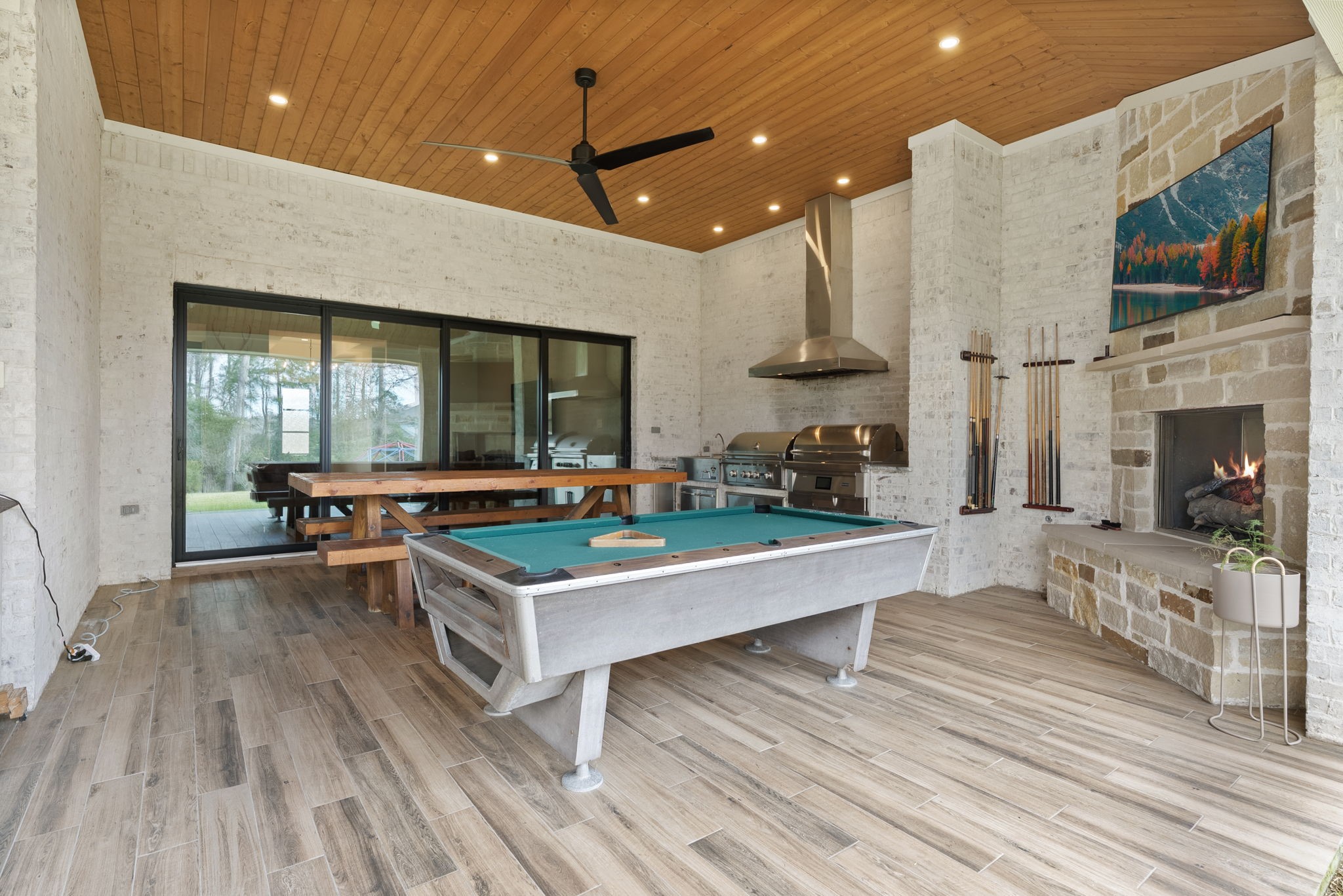 14019 Beartooth Bend Trail Conroe, TX 77384 - Photo 25 of 28 Covered outdoor living area with built-in Summer kitchen and fireplace, ideal for year-round entertaining.