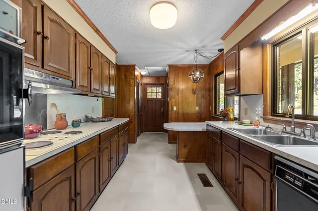 a large kitchen with stainless steel appliances a sink and cabinets