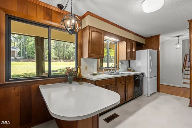 a kitchen with stainless steel appliances granite countertop sink stove and refrigerator