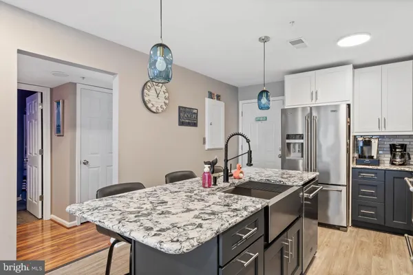a kitchen with stainless steel appliances granite countertop a sink refrigerator and cabinets