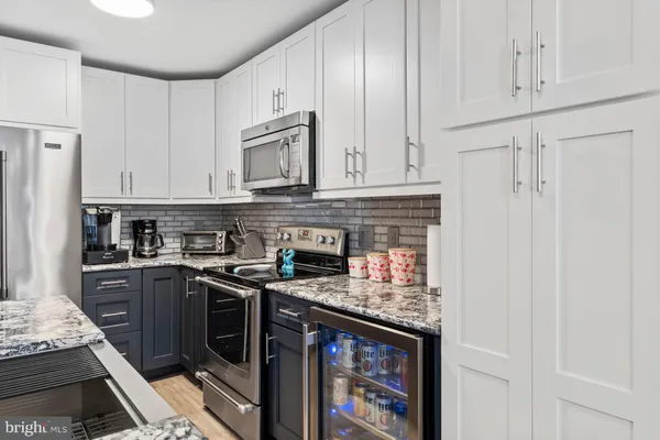 a kitchen with stainless steel appliances granite countertop a stove and a refrigerator