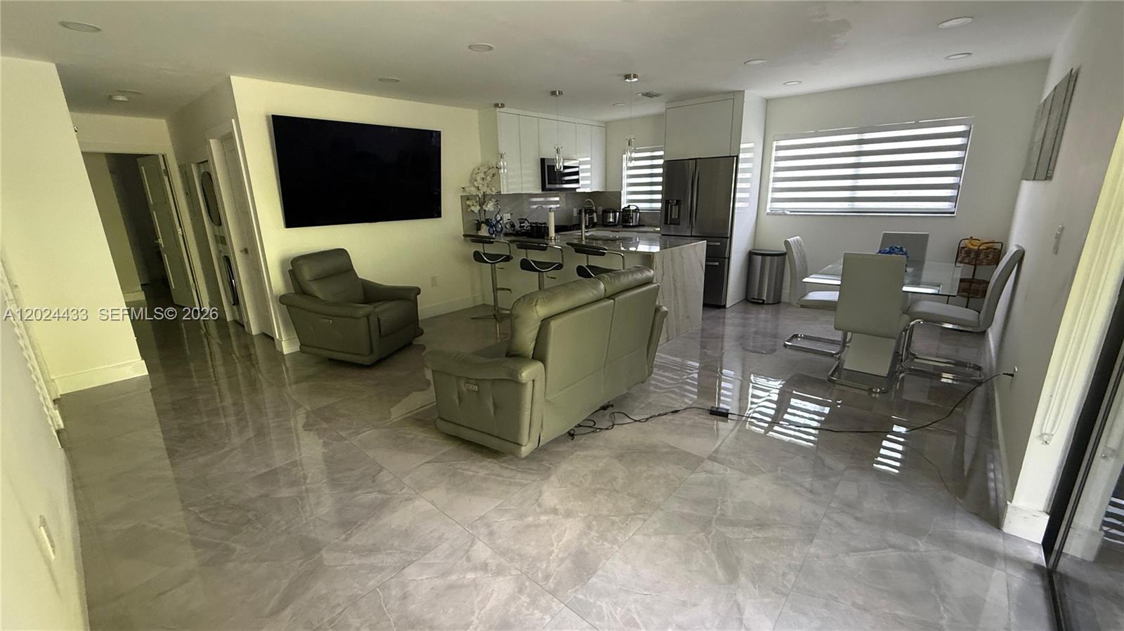 13675 Southwest 62nd Street, Unit 2023 Miami, FL 33183 - Photo 7 of 22 a living room with furniture and a flat screen tv