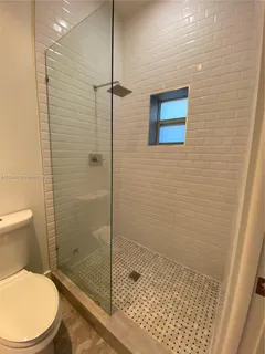 a bathroom with a toilet and a shower