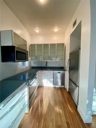 a kitchen with granite countertop a refrigerator and a sink
