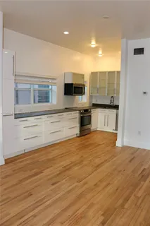 a view of a kitchen with wooden floor and a sink