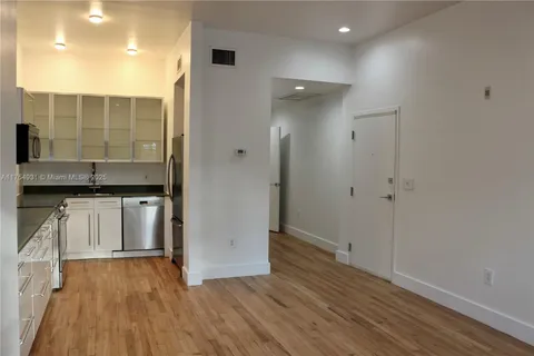 a kitchen with stainless steel appliances a sink dishwasher a refrigerator and a stove top oven