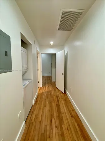 a view of a hallway with wooden floor