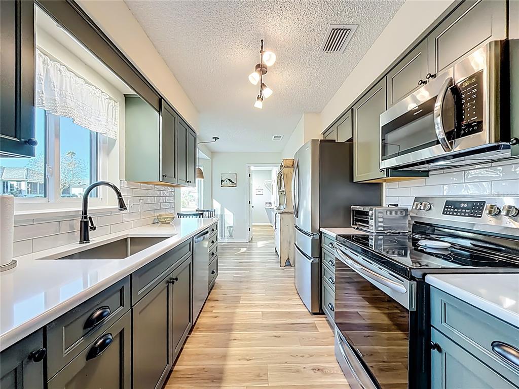 5226 Northwest 21st Loop Ocala, FL 34482 - Photo 11 of 57 a kitchen with stainless steel appliances granite countertop a sink and a stove
