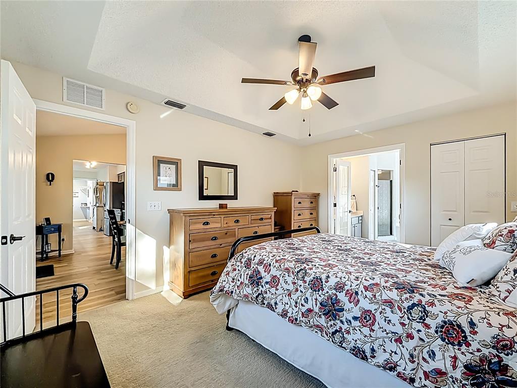 5226 Northwest 21st Loop Ocala, FL 34482 - Photo 19 of 57 a bedroom with a large bed and a chandelier