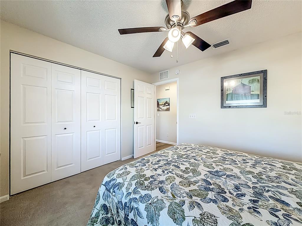 5226 Northwest 21st Loop Ocala, FL 34482 - Photo 26 of 57 a bedroom with a large bed and a chandelier fan