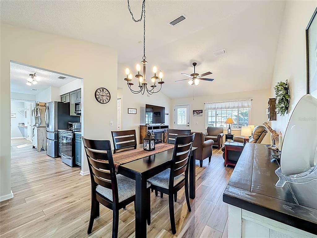 5226 Northwest 21st Loop Ocala, FL 34482 - Photo 9 of 57 a view of a dining room with furniture a chandelier and wooden floor