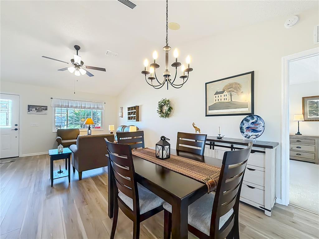 5226 Northwest 21st Loop Ocala, FL 34482 - Photo 10 of 57 a view of a dining room with furniture wooden floor and a chandelier