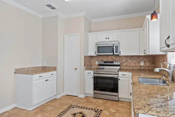 a kitchen with a sink stove and cabinets