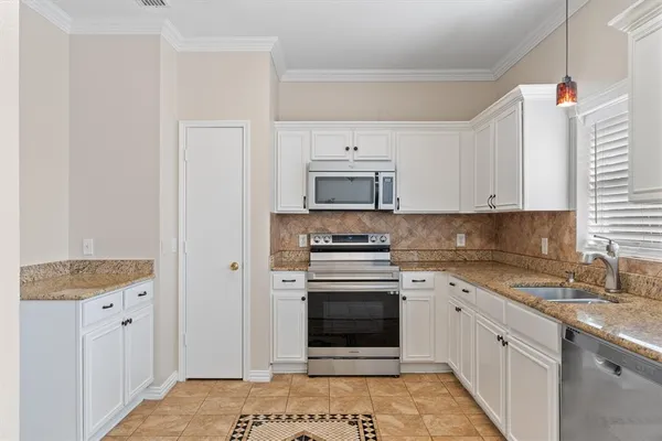 a kitchen with granite countertop white cabinets and white appliances