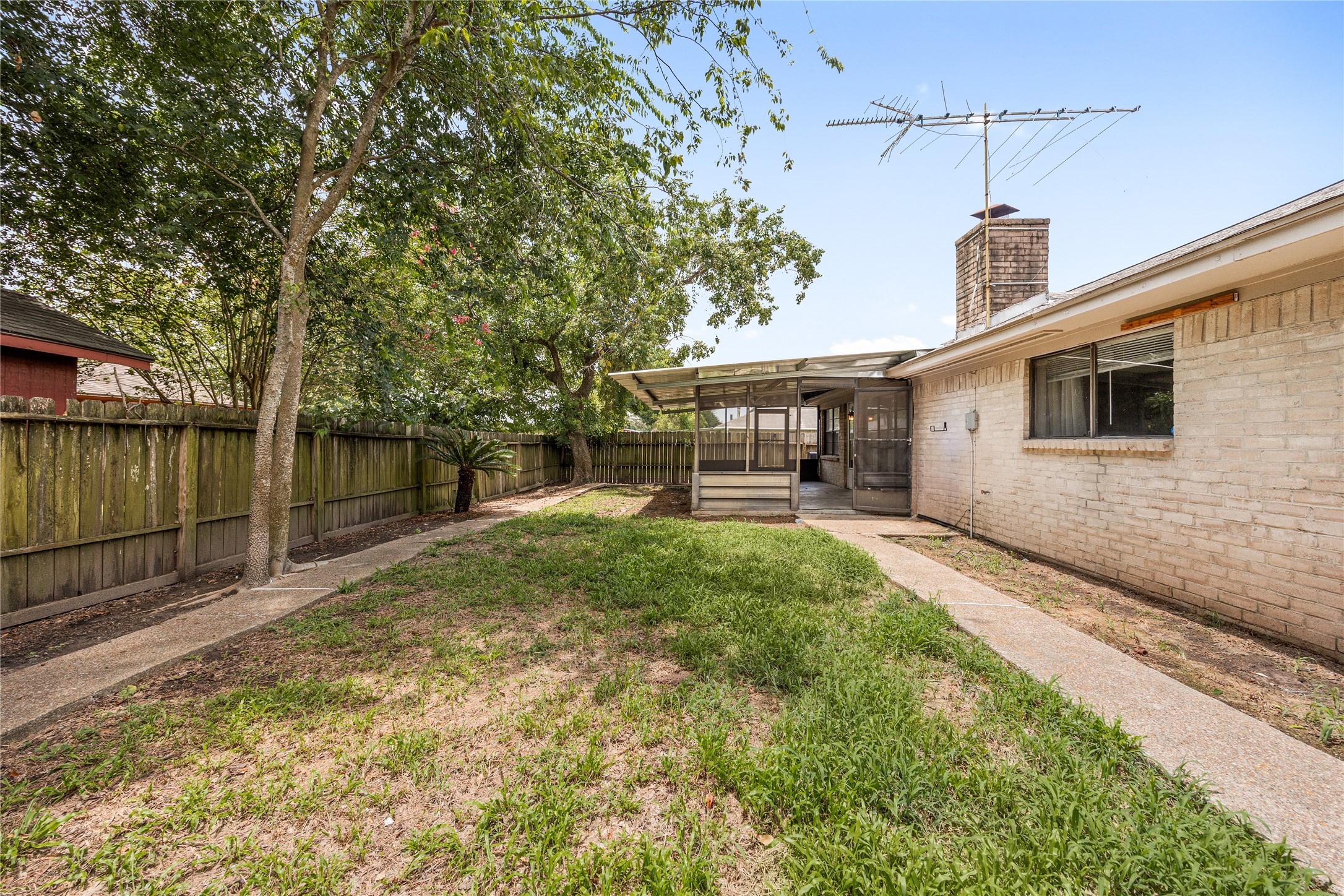 6602 Fallengate Drive Spring, TX 77373 - Photo 21 of 24 Generous backyard space featuring a grassy lawn, a full wooden privacy fence, mature trees for natural shade, and a concrete walkway.