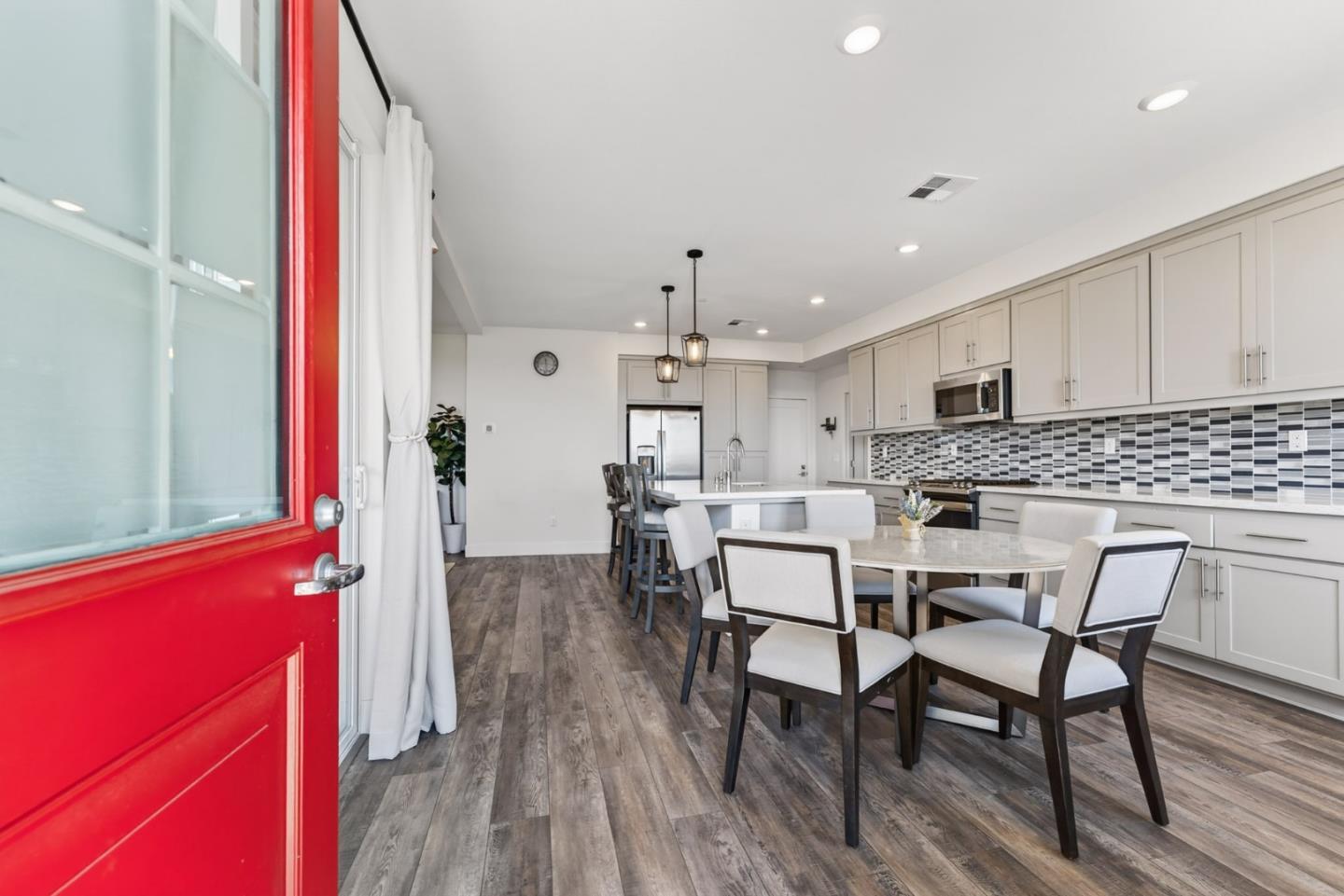 9532 Seawind Way Newark, CA 94560 - Photo 6 of 44 a kitchen with stainless steel appliances kitchen island granite countertop a dining table chairs and white cabinets