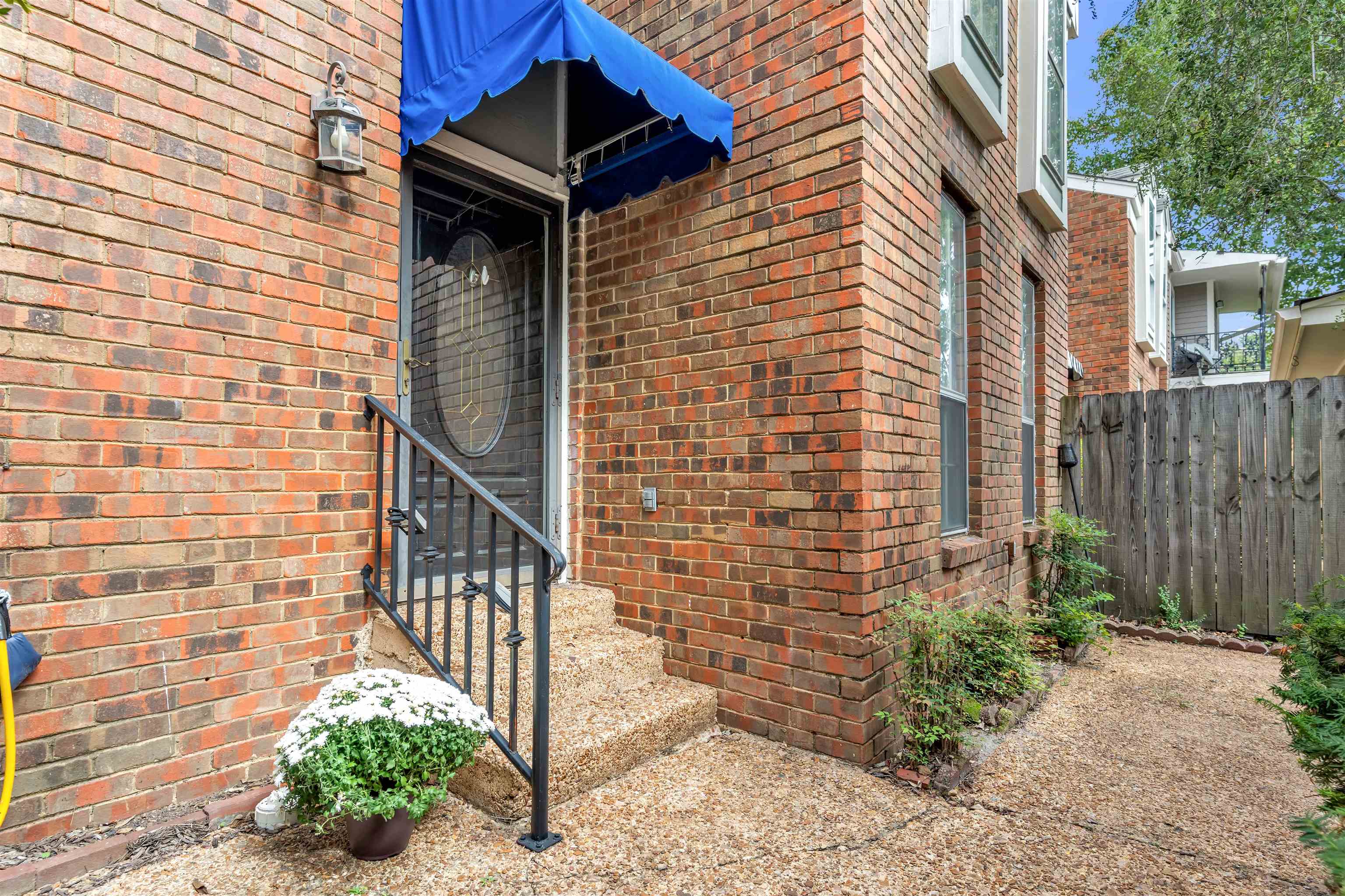 a brick house with a small yard and wooden fence